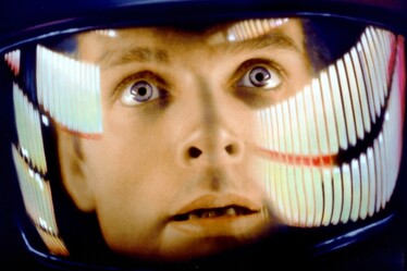 A still image from the movie 2001 A Space Odyssey. Astronaut Dave Bowman looks out in wonder from his space helmet